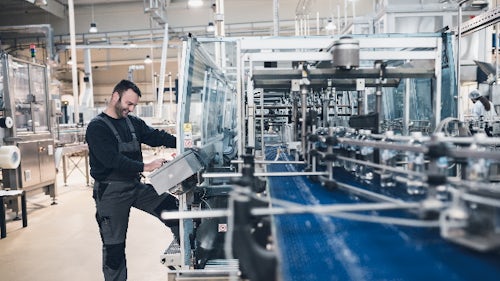Man in a factory utilizing quality tools to ensure productivity and quality management
